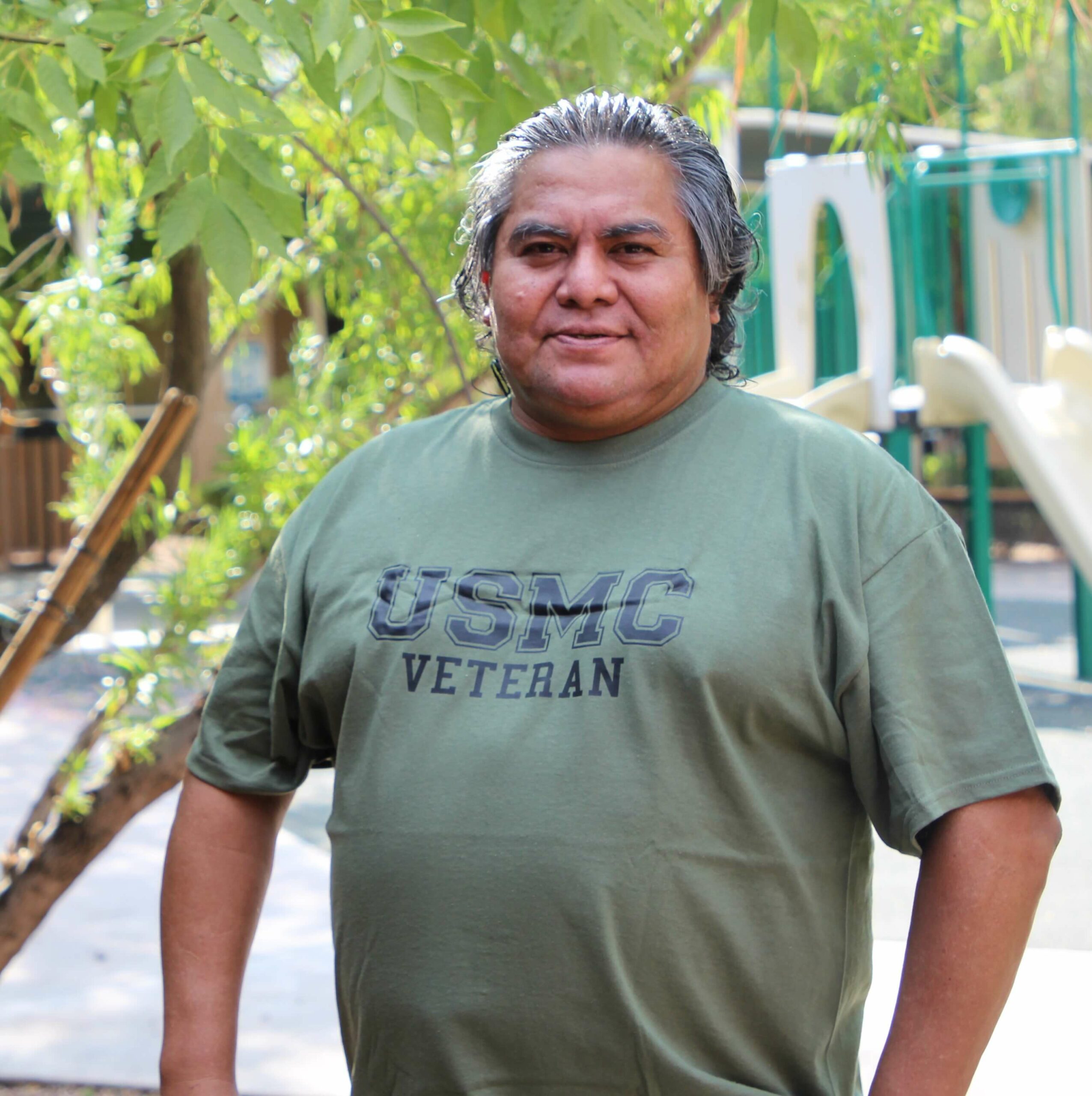 Dave stands proudly at his Desert Leaf apartment in his USMC Veteran shirt